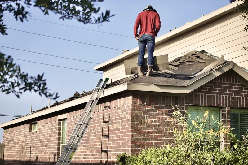 Professional roofer working on a residential roof in Cable